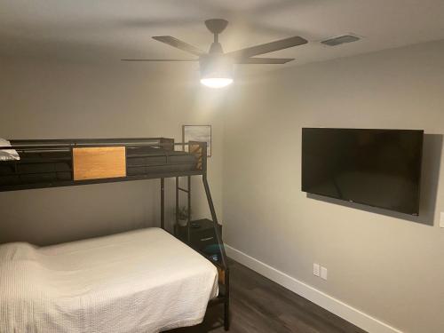 a bedroom with a bunk bed and a flat screen tv at Clear Lake Retreat: Private pool, lakefront in Orlando