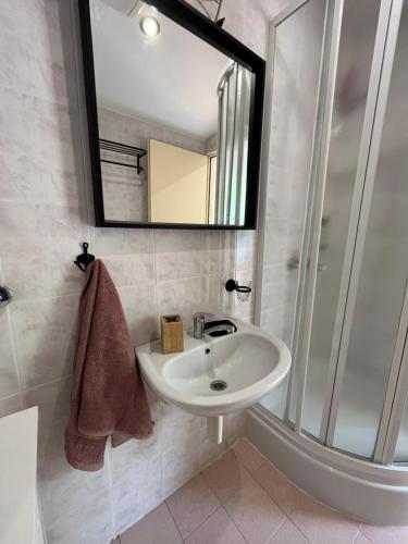 een badkamer met een wastafel en een spiegel bij Studio apartment 2+1 in Ivan Dolac
