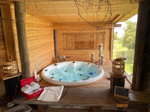uma banheira de hidromassagem num quarto de madeira com duas velas em Le Rondini- Solo Adultos em Montrás