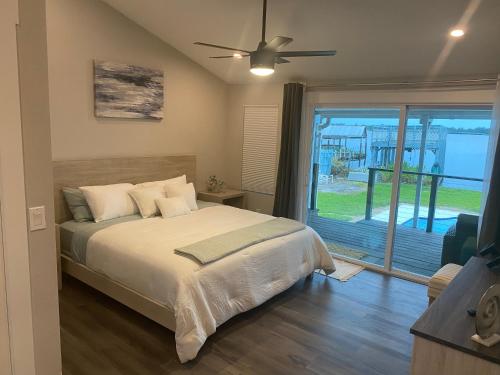 a bedroom with a bed and a sliding glass door at Clear Lake Retreat: Private pool, lakefront in Orlando