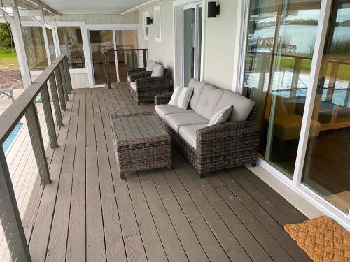 a porch with couches and chairs on a house at Clear Lake Retreat: Private pool, lakefront in Orlando
