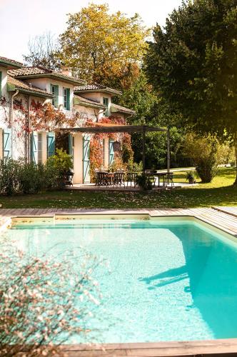 une grande piscine devant une maison dans l'établissement BEL AIR MAISON D'HOTES DES LANDES, à Castets