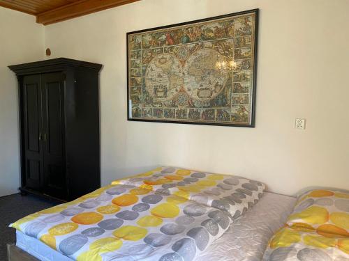 a bedroom with a bed and a painting on the wall at Chalupa u Lipna in Nová Pec