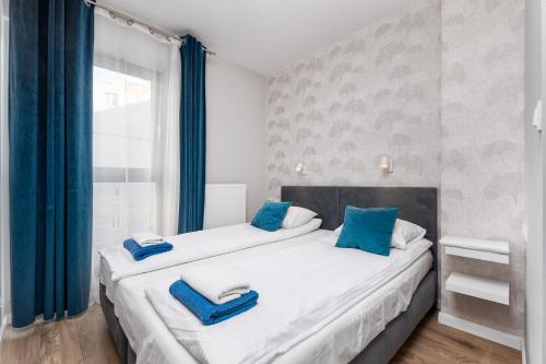 two beds in a room with blue pillows at Chłodna Apartment by Your Freedom in Warsaw