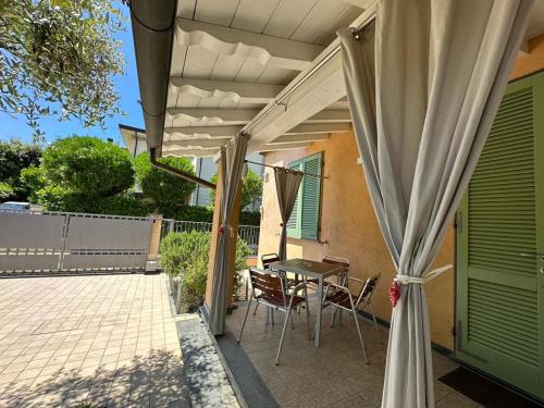 a patio with a table and chairs under a pergola at La casa di Elena Versilia - Two Apartments in Marina di Pietrasanta