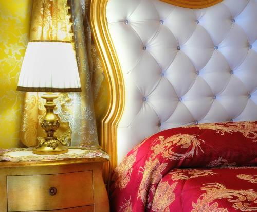 a lamp on a night stand next to a bed at La Dolce Vita - Luxury House in Agrigento