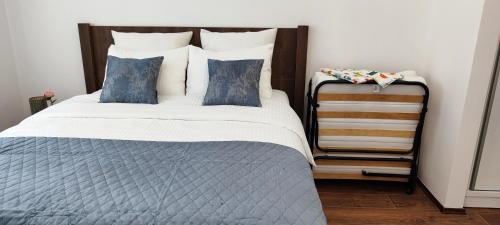 a bedroom with a large bed with blue pillows at Apartman Modiano in Vrnjačka Banja
