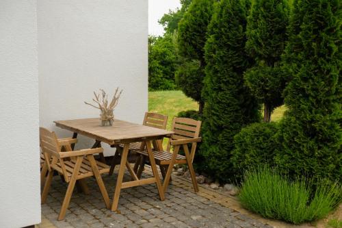 Une table et des chaises en bois sont disponibles sur la terrasse. dans l'établissement Villa Natalia, à Rusinowo