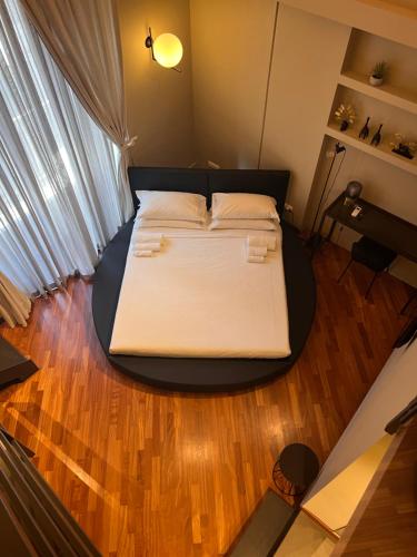 Cama grande en habitación con suelo de madera en Duomo Housing Catania Le Suites, en Catania