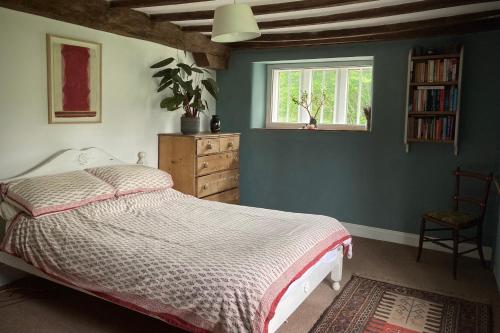 1 dormitorio con cama y ventana en Whichford Mill-large Cotswold Home, en Shipston on Stour