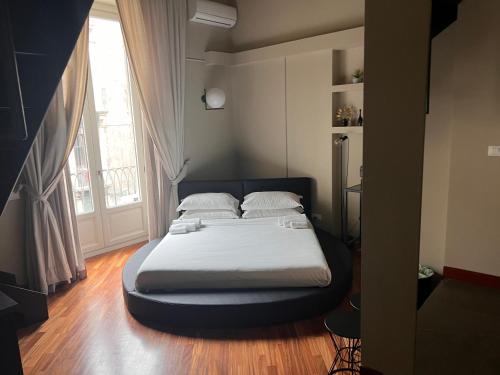 łóżko w pokoju z dużym oknem w obiekcie Duomo Housing Catania Le Suites w Katanii
