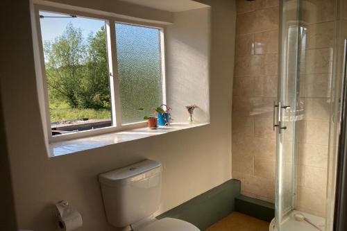 baño con aseo y ventana en Whichford Mill-large Cotswold Home, en Shipston on Stour