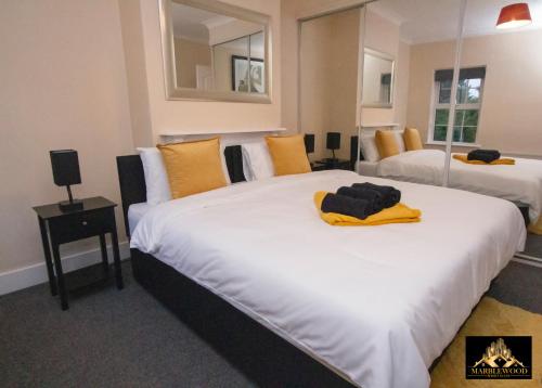 a hotel room with two beds with yellow pillows at Modern Luxury house in Farnborough in Farnborough