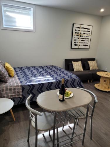 Habitación con cama y mesa con botella de vino en Studio sous-sol Lachine 10 min de DT, en Montreal