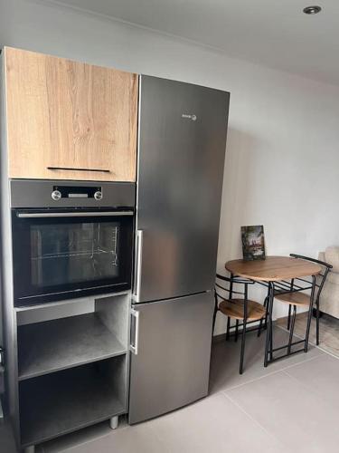 a kitchen with a stainless steel refrigerator and a table at Sparrow apartmens 3 in Košice