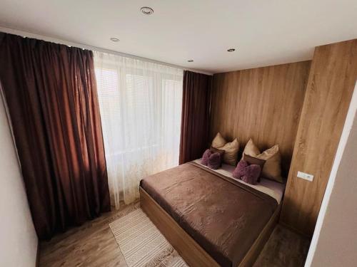 a small bedroom with a bed with purple pillows at Sparrow apartmens 3 in Košice