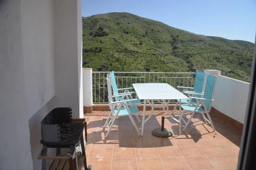 a table and chairs on a balcony with a mountain at Casa Eckhoff 3A Polopos- Underbar utsikt in Polopos
