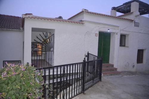 a white house with a gate and a green door at Casa Eckhoff 3A Polopos- Underbar utsikt in Polopos