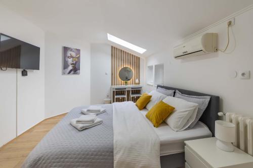 a bedroom with a large bed with yellow pillows at Old Town Rooms in Novi Sad