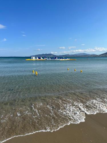 a beach with some yellow buoys in the water at EVa's Luxury Apartments No 1 in Áyios Spirídhon