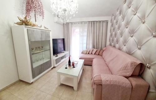 un soggiorno con divano rosa e tavolo di EL APARTAMENTO DE AMY CON VISTAS AL MAR a Mazagón