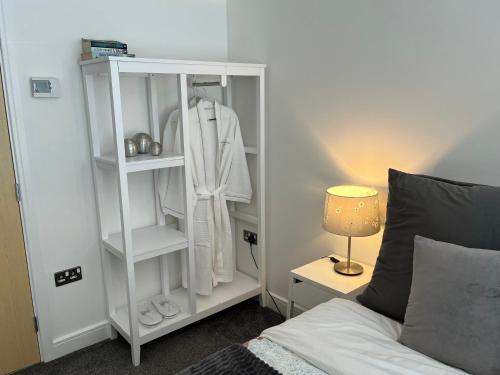 a bedroom with a white book shelf next to a bed at 3 Bed Stylish house with parking close the Etihad in Manchester