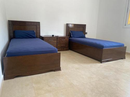 twee bedden met blauwe lakens in een kamer bij CABO CHICO 