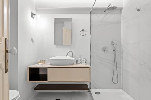 een witte badkamer met een wastafel en een douche bij Cascais Terrace in Cascais