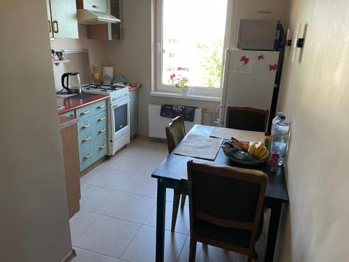a kitchen with a table and a refrigerator at Happy Guest Apartament in Jūrmala