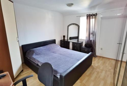a bedroom with a bed and a dresser and a mirror at Holiday home Kastel Stari in Kaštela