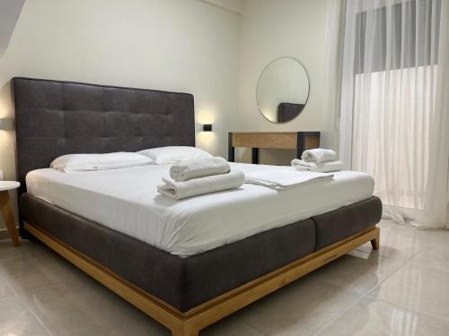 una camera da letto con un letto grande con asciugamani sopra di Sun & Stone House a Polykhrono