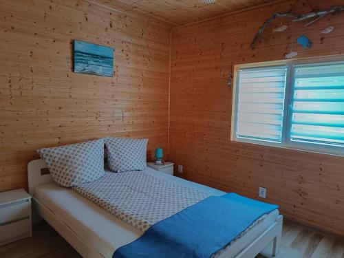 a bedroom with a bed in a wooden wall at Villa Natalia in Rusinowo