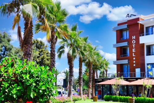 a hotel with palm trees in front of a building at MIRANDA HOTEL - Tanger in Tangier