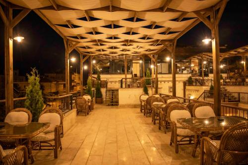 an empty restaurant with tables and chairs at night at Garden Suites Hotel Cappadocia in Göreme