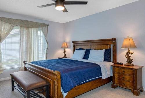 - une chambre avec un lit doté de draps bleus et d'un ventilateur dans l'établissement 13 Mins From Disney Arcade, Private Pool, Themed Rooms & HotTub, à Orlando