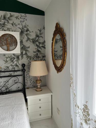 a bedroom with a bed with a lamp and a mirror at Da Tea in San Teodoro