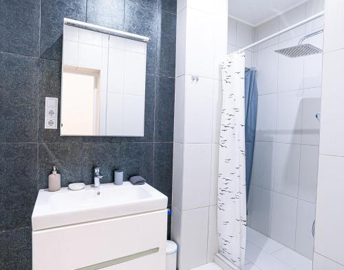 Baño blanco con lavabo y espejo en Joy Apartments on Kiraly street, en Budapest
