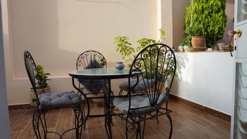 a table with four chairs and a table with plants at riad casa bahia asilah in Asilah