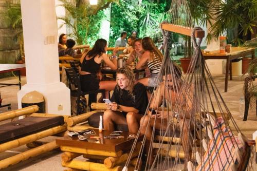 a woman sitting in a hammock in a restaurant at Paradise Project Hostal in Montañita