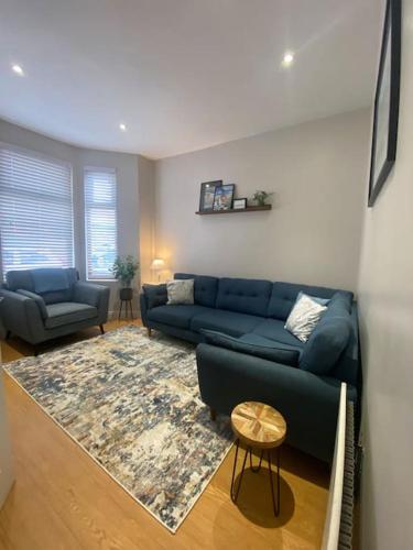 a living room with a blue couch and a rug at Baker House (Ormeau Road) 4Bed in Belfast