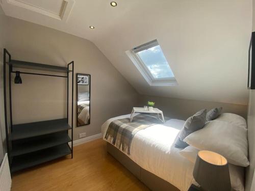 a bedroom with a bed and a skylight at Baker House (Ormeau Road) 4Bed in Belfast