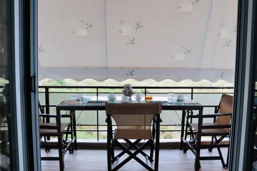 a dining room table with chairs and a window at Corali luxury apartments in Malaki