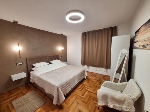 a bedroom with a bed and a chair in it at Apartman K. & M. KOLUMBIĆ in Sveta Nedelja