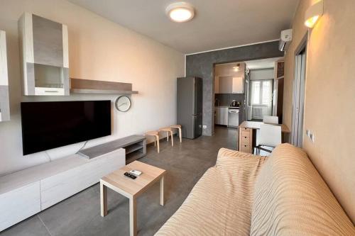 a living room with a couch and a large television at Suite Riminese with Beach Service in Rimini