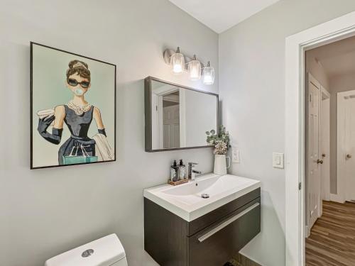 un baño con lavabo y una pintura de una mujer en Miami Residential, en North Miami