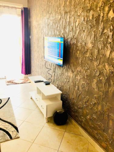 ein Wohnzimmer mit einem TV an der Wand in der Unterkunft SJ Homes in Kampala