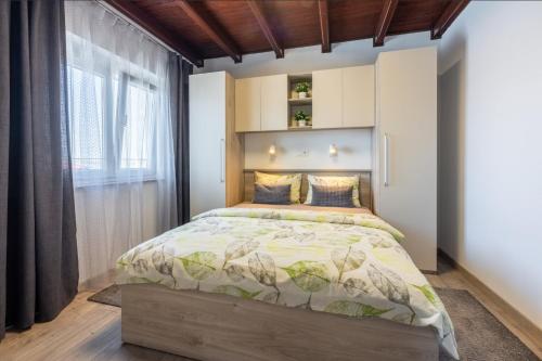 a bedroom with a bed and a large window at Apartments Lino in Selce