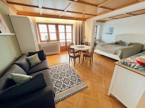 Sala de estar con sofá, cama y mesa en Haus Bergblick en Rettenberg