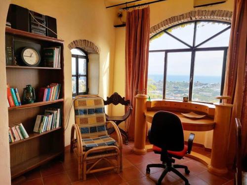 um quarto com uma secretária, cadeiras e uma janela em CASA MARIA Huge apartment in the heart of Bussana Vecchia em Sanremo