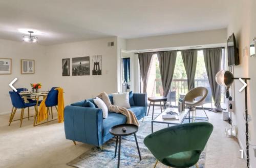 sala de estar con sofá azul y sillas en Comfort & Covenience, en Laurel
